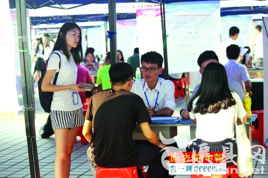 11月18日，陈良岸(右)在广东科技学院招聘会上设点招聘员工。