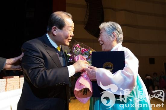 88岁的辛福顺奶奶正从麻浦区厅长朴兴协手中接过奖状和鲜花。