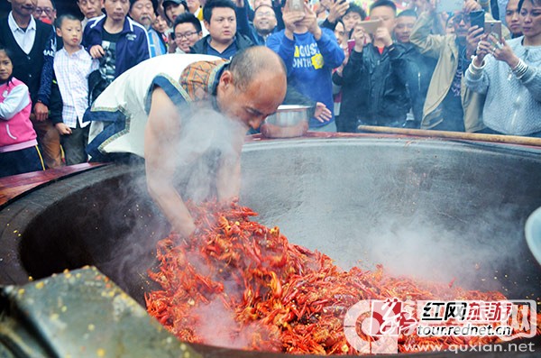 “鬼谷神功”大师唐程刚将手伸进油锅，翻炒龙虾。