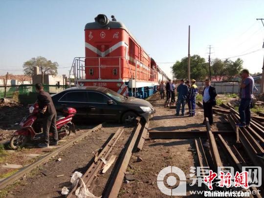 黑龙江一轿车抢越铁路道口与机车头相撞幸无伤亡 钟欣 摄